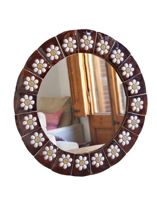 Round mirror with floral decorative frame on a white background